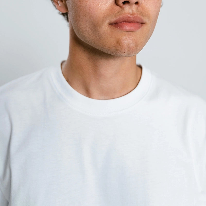 Close-up of a white t-shirt neckline worn by a male model – fabric texture showcase by Kadam Colors.