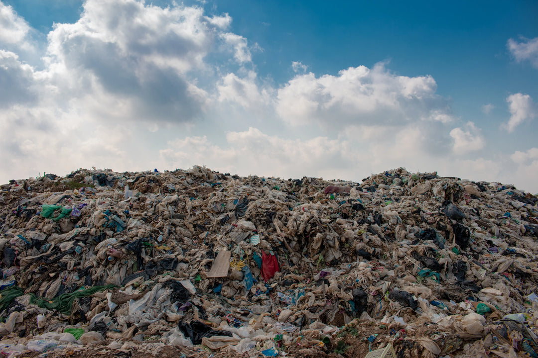 Massive landfill of textile and plastic waste—highlighting Kadam Colors’ mission to reduce fabric waste through sustainable dyeing.