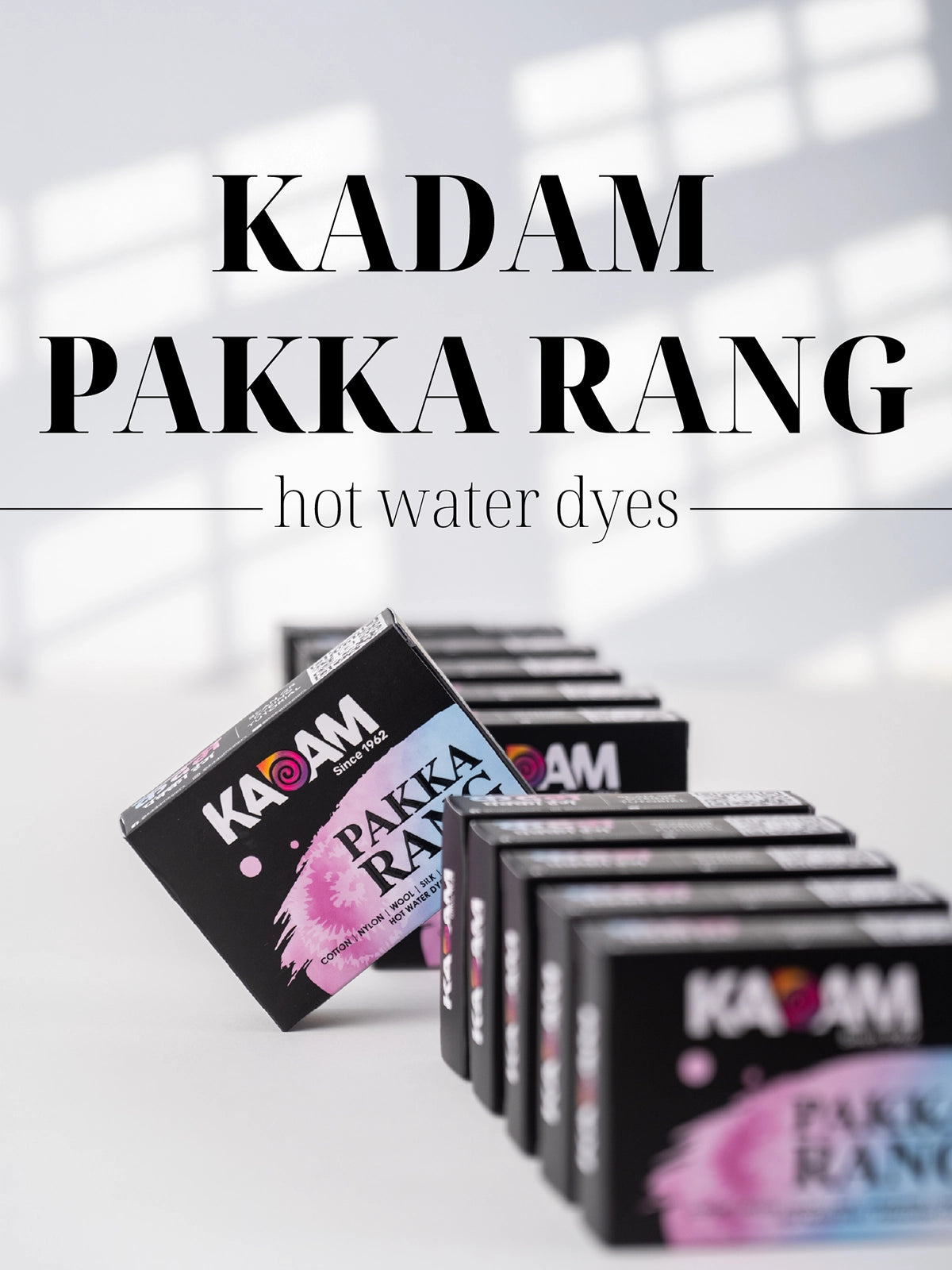 Diagonal lineup of Kadam Colors Pakka Rang boxes on white background with bold text "Kadam Pakka Rang Hot Water Dyes".